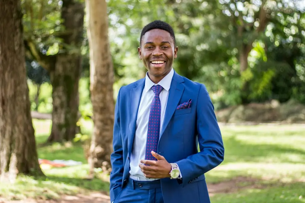 A professional in a blue suit smiling outdoors