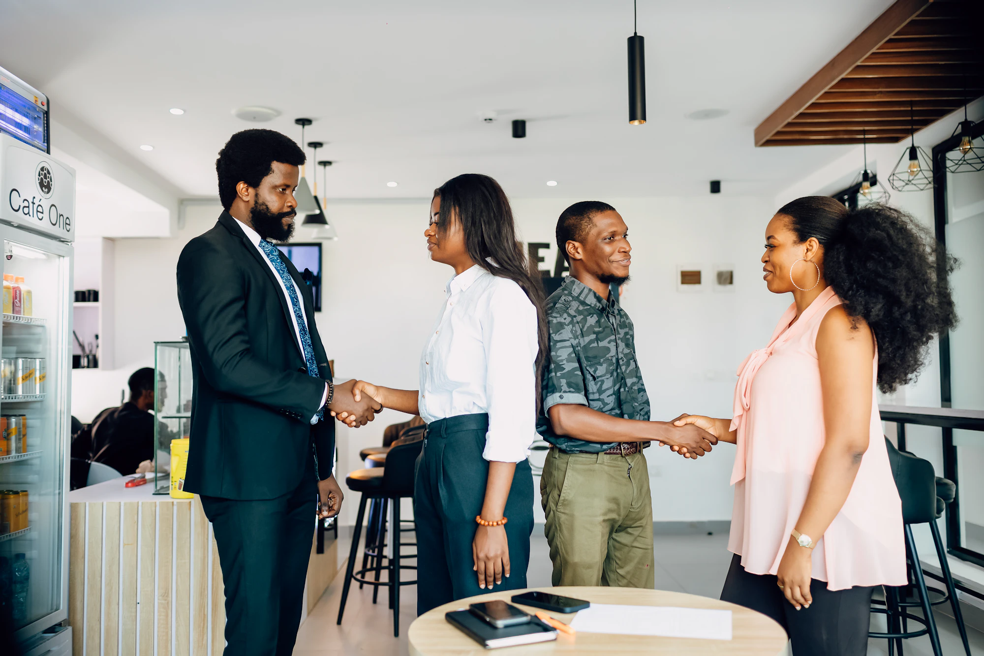 Colleagues greeting each other with handshakes in a modern office