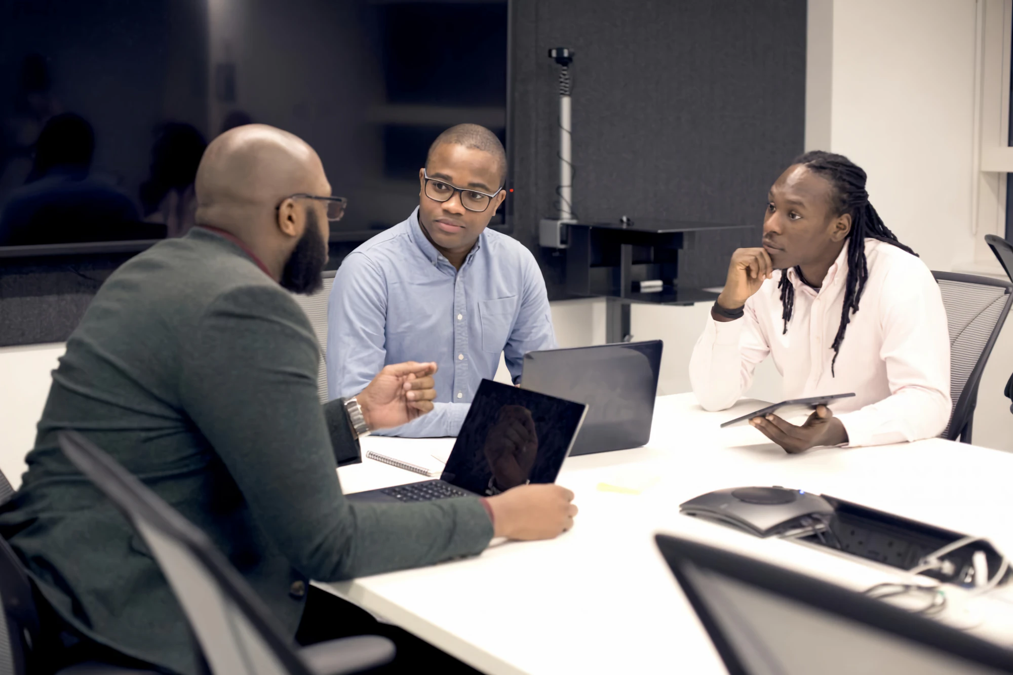 A team meeting around a table with laptops